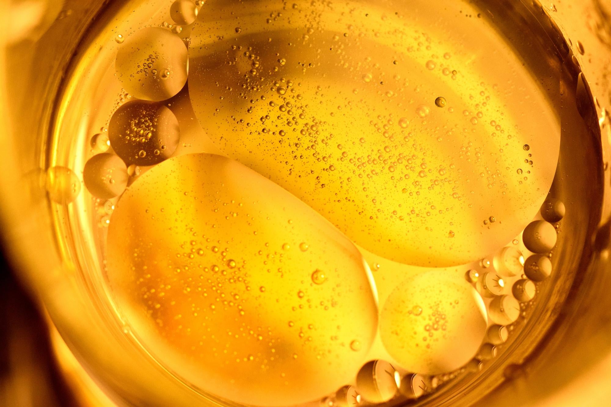 Close-up of a glass with yellow liquid and bubbles
